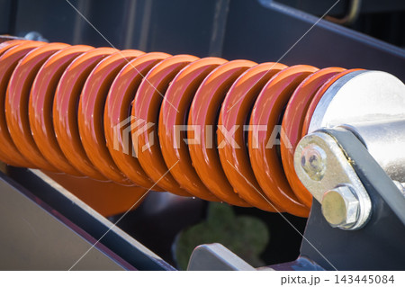Steel spring as part of heavy agricultural, industrial machine. Technology Steel spring as part of heavy agricultural, industrial machine. Technology 143445084