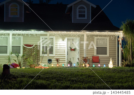 Festive yard display with glowing lights and Christmas decorations at a Florida family home. New Year holiday joy. Festive yard display with glowing lights and Christmas decorations at a Florida family home. New Year holiday joy. 143445485