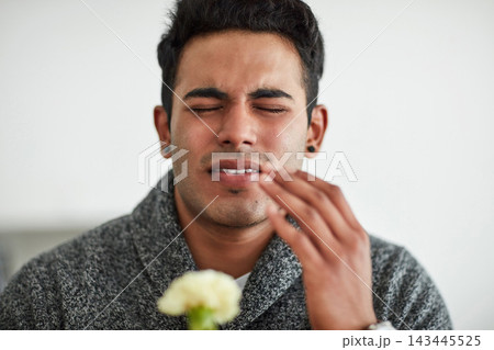 Hand, man or sneeze with flower for allergies, hay fever or nasal congestion in living room. Male person, sick or discomfort of rhinitis for medical virus, sinusitis or inflammation of plant in home 143445525