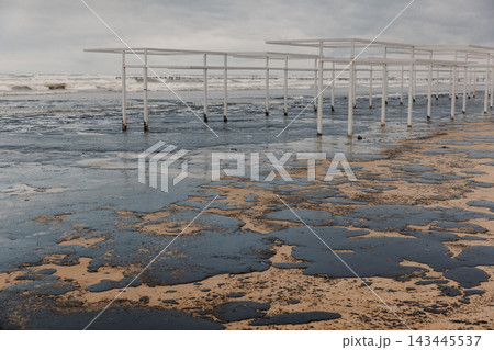 Beach and sea polluted with oil. Beach oil fuel spill impact, pollution, waste disposal. Beach and sea polluted with oil. Beach oil fuel spill impact, pollution, waste disposal. 143445537