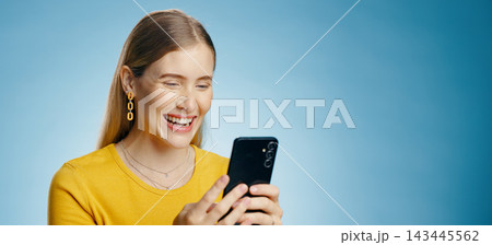 Funny, woman and phone text in studio with social media, smile and meme with mockup for banner. Digital, email and technology with typing, blog and mobile app with notification and blue background 143445562