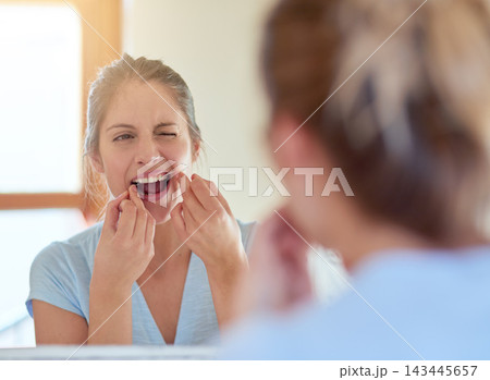 Woman, mirror and floss in morning for dental health in bathroom with cleaning for hygiene. Reflection, house and oral care for fresh breath with white teeth, wellness and daily routine in Canada. Woman, mirror and floss in morning for dental health in bathroom with cleaning for hygiene. Reflection, house and oral care for fresh breath with white teeth, wellness and daily routine in Canada. 143445657
