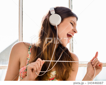 Woman, headphones and music streaming or singing at home for playlist subscription, entertainment or listening. Female person, happy and dancing with radio app for audio podcast, hearing or track Woman, headphones and music streaming or singing at home for playlist subscription, entertainment or listening. Female person, happy and dancing with radio app for audio podcast, hearing or track 143446087