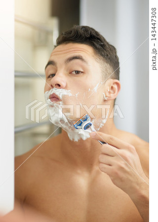 Man, shaving and razor by mirror in bathroom for hygiene, cleaning or check face in morning at house. Person, cosmetics and topless in reflection, grooming or wellness with foam, change and self care Man, shaving and razor by mirror in bathroom for hygiene, cleaning or check face in morning at house. Person, cosmetics and topless in reflection, grooming or wellness with foam, change and self care 143447308