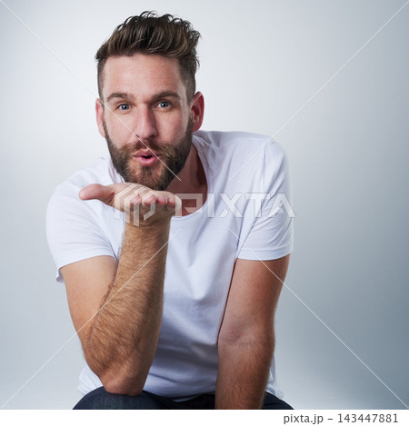 Romantic, blowing kiss and portrait of man in studio for flirting, affection or love expression. Valentines day, anniversary and face of male model and gesture on white background for passion or date 143447881