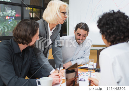 Teamwork brainstorm. Coworkers cooperating working together at office meeting. Colleagues discussing project ideas. Group of people in creative office discussing business. Young professional team Teamwork brainstorm. Coworkers cooperating working together at office meeting. Colleagues discussing project ideas. Group of people in creative office discussing business. Young professional team 143448201