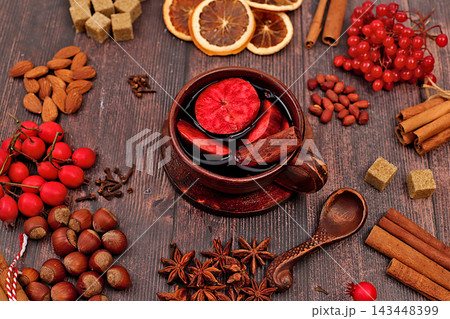 Autumn abstract composition featuring hot mulled wine, spices, burnt sugar, cloves, nuts, cinnamon, star anise, rowan berries, and rose hips, still life,Thanksgiving concept, seasonal background 143448399