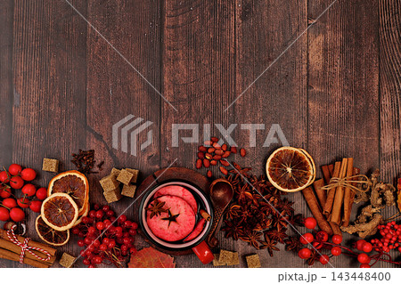 Autumn abstract composition featuring hot mulled wine, spices, burnt sugar, cloves, nuts, cinnamon, star anise, rowan berries, and rose hips, still life,Thanksgiving concept, seasonal background 143448400