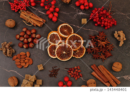 Abstract winter still life for the cold season.Recipe for delicious mulled wine featuring dried oranges, burnt sugar, cloves, nuts, cinnamon, star anise, rowan berries and rosehips Abstract winter still life for the cold season.Recipe for delicious mulled wine featuring dried oranges, burnt sugar, cloves, nuts, cinnamon, star anise, rowan berries and rosehips 143448401