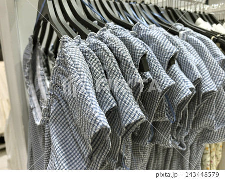 Charming display of stylish blue checkered clothes in a retail store Charming display of stylish blue checkered clothes in a retail store 143448579