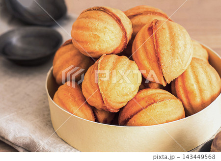 homemade cookies shaped nuts with cream boiled condensed milkt on wooden table. 143449568