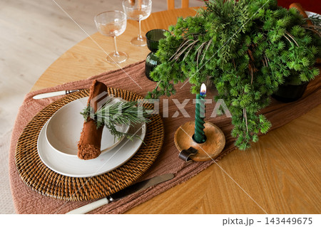 Setting a dining table with simple decor and natural elements for a meal gathering in a warm space 143449675