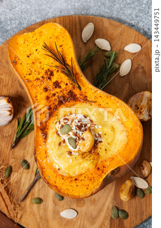 Delicious roasted butternut squash with creamy filling and toppings in a cozy kitchen setting 143449751