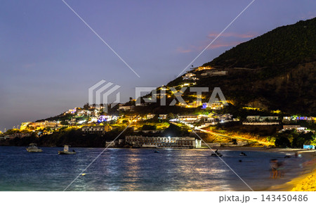 Scenic dusk view of illuminated hillside villas and resorts along the coast of Great Bay in Philipsburg, Sint Maarten. 143450486