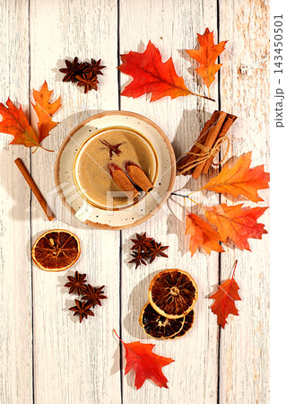 Seasonal abstract composition with hot autumn drink, coffee with foam, and Indian masala chai and fallen leaves, star anise and cinnamon, banner for screen, autumn greeting concept, mockup for menu. 143450501