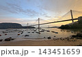 Suspension Hong Kong bridge spanning across a calm bay at sunset with small boats anchored near the shore Suspension Hong Kong bridge spanning across a calm bay at sunset with small boats anchored near the shore 143451659