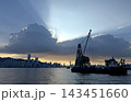 Silhouette of a construction barge on the water against a dramatic sunset Hong Kong city skyline view Silhouette of a construction barge on the water against a dramatic sunset Hong Kong city skyline view 143451660
