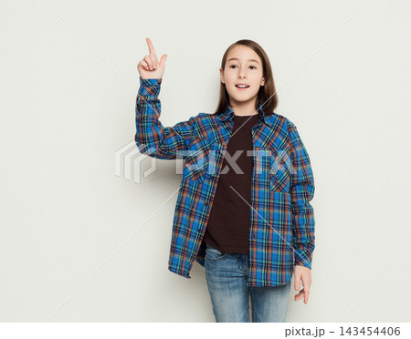 Young happy girl having great idea, raising hand upwards. Found something interesting, eureka, success concept, white studio background Young happy girl having great idea, raising hand upwards. Found something interesting, eureka, success concept, white studio background 143454406