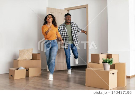 Joyful Young Black Couple, Smiling And Energetic, Moving Into New Home Together, Unpacking Boxes In Modern Interior, Celebrating New Beginning. Weight Loss Concept. Joyful Young Black Couple, Smiling And Energetic, Moving Into New Home Together, Unpacking Boxes In Modern Interior, Celebrating New Beginning. Weight Loss Concept. 143457196