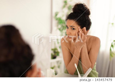 Worried Young Hispanic Woman Concerned About Skin Issues While Examining Face In Front Of Mirror At Home. Taking Care Of Skin Routine, Copy Space Available For Text, Healthcare Concept. Worried Young Hispanic Woman Concerned About Skin Issues While Examining Face In Front Of Mirror At Home. Taking Care Of Skin Routine, Copy Space Available For Text, Healthcare Concept. 143457479