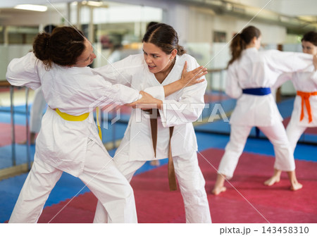 Women practicing a body punch in training Women practicing a body punch in training 143458310