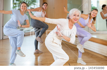 Females doing dance workout during group classes in fitness center 143458890