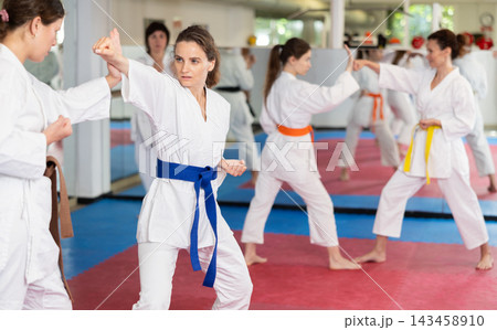 Women pupils train to perform defensive karate installations and attacking combat techniques Women pupils train to perform defensive karate installations and attacking combat techniques 143458910