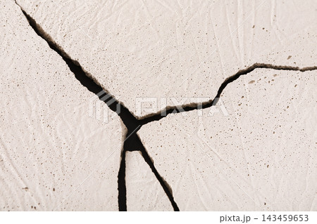 A close view of cracked earth displaying deep fissures and textures. The cracks form interesting patterns, showing the effects of dryness over time. The light captures the details well. A close view of cracked earth displaying deep fissures and textures. The cracks form interesting patterns, showing the effects of dryness over time. The light captures the details well. 143459653