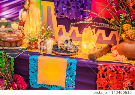 Decorative skull beside candles and flowers on a Mexican remembrance altar. Spanish text Queretaro, y entonces encontre Mexico means Queretaro, and then I found Mexico. 143460630