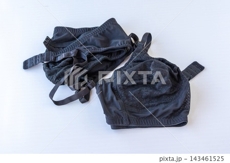Pair of black feminine lace brassieres displayed on white surface. Women innerwear clothing collection for commercial shop presentation. Pair of black feminine lace brassieres displayed on white surface. Women innerwear clothing collection for commercial shop presentation. 143461525