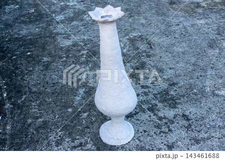 Handmade paper mache flower vase placed on textured concrete floor outdoors. Eco friendly recycled paper craft artwork. Handmade paper mache flower vase placed on textured concrete floor outdoors. Eco friendly recycled paper craft artwork. 143461688