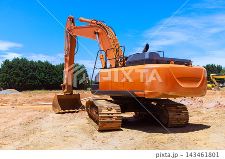 Excavator is digging at construction site surrounded by trees Excavator is digging at construction site surrounded by trees 143461801