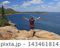 Teenager girl admiring the Aerial view of Sand Beach and Acadia National Park coastline from Otter Point Overlook, USA 143461814