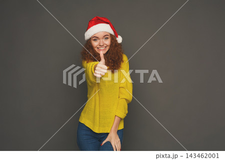 A person shows excitement and joy with a thumbs up gesture while wearing a yellow sweater and a Christmas hat. This collage captures festive spirit during the holiday season. A person shows excitement and joy with a thumbs up gesture while wearing a yellow sweater and a Christmas hat. This collage captures festive spirit during the holiday season. 143462001
