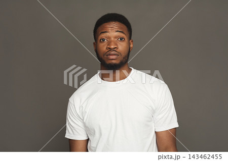 A young man poses alone against a plain background. He appears serious and thoughtful. This is part of a collage that shows various emotions and expressions. A young man poses alone against a plain background. He appears serious and thoughtful. This is part of a collage that shows various emotions and expressions. 143462455