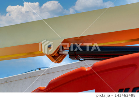 Hydraulic piston and metal joint on articulated aerial boom lift outdoors, heavy construction machinery designed for lifting, engineering, repair and industrial maintenance at height. Hydraulic piston and metal joint on articulated aerial boom lift outdoors, heavy construction machinery designed for lifting, engineering, repair and industrial maintenance at height. 143462499