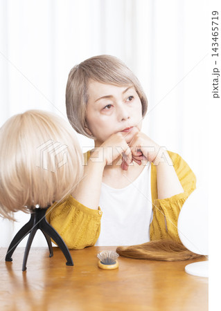 薄毛に悩みウイッグをつけるシニア女性 143465719