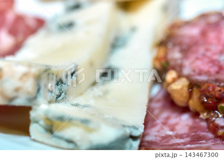 Close-up view of sliced blue cheese and cured meats on a platter Close-up view of sliced blue cheese and cured meats on a platter 143467300