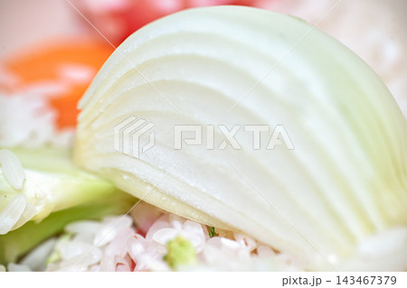 Close-up shot of a sliced fresh white onion wedge with rice and vegetables 143467379