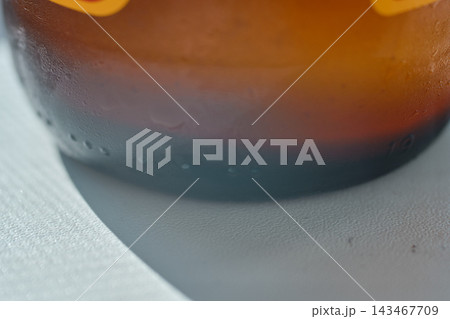 Close-up shot of a cold glass bottle of ginger beer with condensation droplets. 143467709