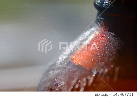 A close-up shot of a cold sweating glass bottle filled with ginger beer A close-up shot of a cold sweating glass bottle filled with ginger beer 143467711