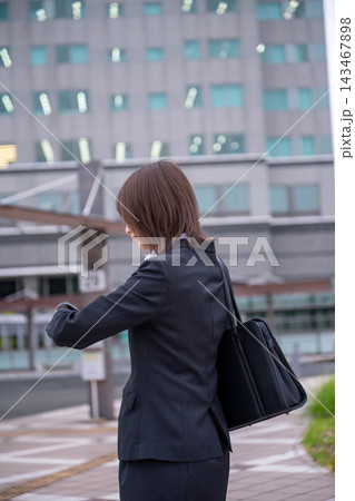 街中で時計を見るビジネスウーマン 143467898