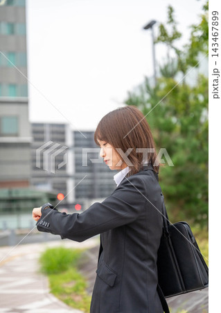 街中で時計を見るビジネスウーマン 街中で時計を見るビジネスウーマン 143467899