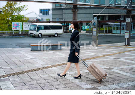 キャリーバッグを持って歩く女性 143468084