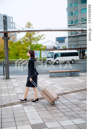 キャリーバッグを持って歩く女性 143468086