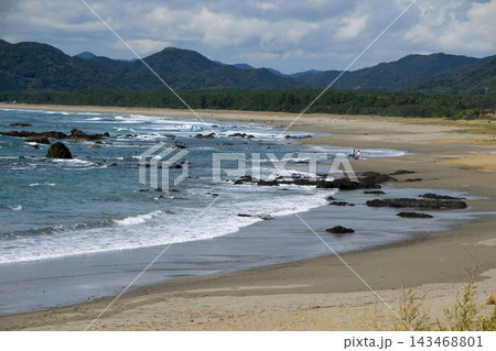 潮が引いた遠浅の海岸と遠くに見える山々 143468801