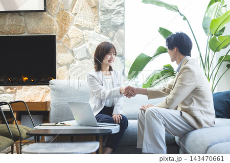 笑顔で握手を交わす男女 143470661
