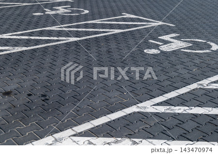 A clear parking area marked with symbols for people with disabilities, providing easy access and convenience for those in need A clear parking area marked with symbols for people with disabilities, providing easy access and convenience for those in need 143470974