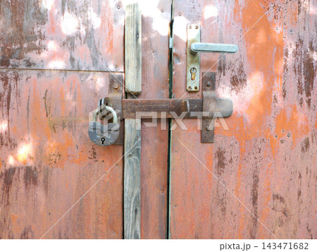 iron bolt and padlock on a closed door 143471682