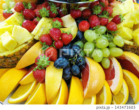 assorted ripe fruits and berries on a white plate assorted ripe fruits and berries on a white plate 143471683